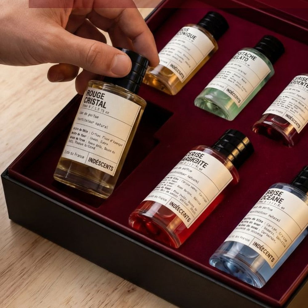 Une main choisit un flacon dans le coffret Indéscents